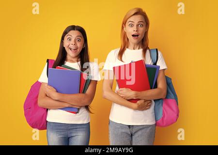 Portrait des jeunes filles émotionnelles expressives. Concept d'école, d'apprentissage et d'éducation. Mère et fille écolières avec sac à dos et livres scolaires Banque D'Images