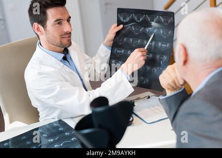 médecin examinant le film radiographique avec le patient à l'hôpital Banque D'Images