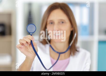 médecin tenant la partie en châtaignier d'un stéthoscope Banque D'Images