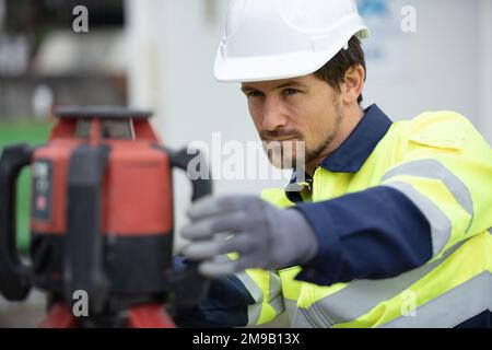 ouvrier de construction mesurant le chantier de construction Banque D'Images