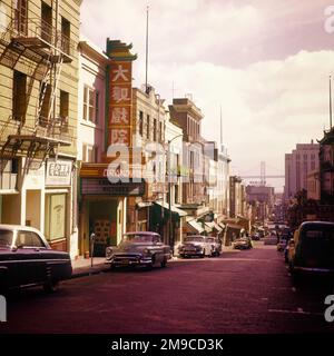 1950S SAN FRANCISCO CHINATOWN STREET AVEC LE PONT DE LA BAIE D'OAKLAND À DISTANCE - KR132343 CPC001 VOITURES HARS CHINATOWN OAKLAND VÉHICULES EDIFICE SAN FRANCISCO DES PONTS D'ENVERGURE ASIATIQUE-AMÉRICAIN SE JOIGNENT À L'ANCIENNE Banque D'Images