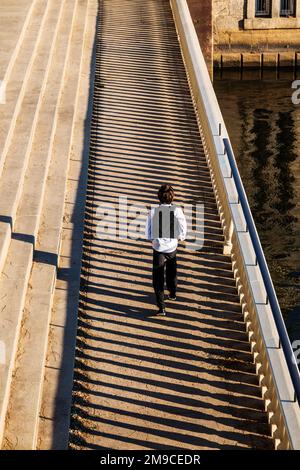 Un jeune garçon sautant tranquillement le long d'un sentier de pierre éclairé par le soleil; Fairmount Water Works; Philadelphie; Pennsylvanie; États-Unis Banque D'Images