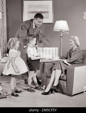 1950S PÈRE FILS ET FILLE DONNANT À LA MÈRE UN CADEAU POUR LA FÊTE DES MÈRES - M3140 HAR001 HARS SUBURBAIN MÈRES VIEUX TEMPS SURPRISE NOSTALGIE FRÈRE VIEILLE MODE SOEUR 1 DONNER STYLE JUVÉNILE JEUNE ADULTE FORT FILS FAMILLES JOIE STYLE DE VIE CÉLÉBRATION FEMMES MARIÉES FRÈRES CONJOINT ÉPOUX SAINTETÉ MAISON VIE COPIE ESPACE AMITIÉ FEMMES FILLES PLEINE LONGUEUR PERSONNES S'OCCUPANT HOMMES FRÈRES ET SŒURS CONFIANCE SŒURS PÈRES B&W. PARTENAIRE BONHEUR ET DADS BAS ANGLE SE SOUVENIR DE FRÈRE CONCEPTUEL ÉLÉGANT ATTACHEMENT PERSONNEL AFFECTION APPRÉCIATION COOPÉRATION ÉMOTION CROISSANCE JUVÉNILES MI-ADULTE MOYEN-ADULTE HOMME Banque D'Images