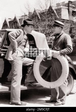 1930S HOMME REPOSANT SUR LE MARCHEPIED D'UNE VOITURE ROADSTER DÉCAPOTABLE DISCUTANT DE L'ACHAT D'UN NOUVEAU PNEU AVEC UNE STATION-SERVICE PRÉPOSÉ - M4537 HAR001 STYLE DE COMMUNICATION HARS CARRIÈRE VÉHICULE INFORMATION SÉCURITÉ EMPLOIS STYLE DE VIE PNEU COPIE ESPACE PERSONNES PLEINE LONGUEUR AUTOMOBILE HOMMES PROFESSION TRANSPORT B&W OBJECTIFS DU CLIENT COMPÉTENCE COSTUME ET CRAVATE PROFESSION VENDRE COMPÉTENCES DISCUTER SERVICE À LA CLIENTÈLE AUTOMOBILE POSTE DE SERVICE CARRIÈRES EXTÉRIEUR CONNAISSANCE EMPLOI EMPLOI EMPLOIS EMPLOIS EMPLOIS AUTOMOBILES SOUTIEN VÉHICULES EMPLOYÉ ACCOMPAGNATEUR ADULTE MOYEN-ADULTE HOMME VENDEURS PNEUS NOIR ET BLANC ORIGINE ETHNIQUE CAUCASIENNE Banque D'Images