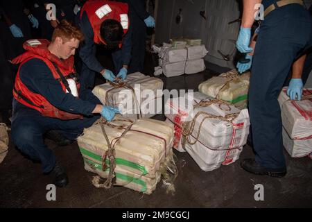 220516-N-TT059-1007 LES marins DU GOLFE D'OMAN (16 mai 2022) à bord du destroyer à missiles guidés USS Momsen (DDG 92) traitent les sacs de stupéfiants illégaux 16 mai. Les drogues ont été saisies dans un navire de pêche dans le golfe d'Oman. Banque D'Images