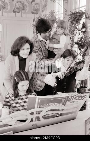 1970S FAMILLE DE 5 AUTOUR DE PIANO PÈRE TIENT LA PETITE MÈRE HOFF SUR LA FILLE JOUANT DU PIANO ET D'AUTRES FILLES JOUANT DU VIOLON - M9459 HAR001 HARS SUBURBAIN URBAIN MÈRES VIEUX TEMPS NOSTALGIE VIEILLE MODE SOEUR VIOLON JEUNE COMMUNICATION TRAVAIL D'ÉQUIPE FAMILLES JOIE STYLE DE VIE SATISFACTION SONORE MUSICIENNE FEMMES MARIÉE 5 ÉPOUX ÉPOUX SAINTETÉ VIE VIE COPIE ESPACE AMITIÉ DEMI-LONGUEUR FEMMES FILLES PERSONNES HOMMES FRÈRES ET SŒURS CONFIANCE SŒURS PÈRES B&W PARTENAIRE ACTIVITÉ BONHEUR LOISIRS ET DADS FIERTÉ OCCASION FRÈRE INSTRUMENT DE MUSIQUE ÉLÉGANT SOUTIEN CRÉATIVITÉ TIENT LES MINEURS ADULTE MOYEN Banque D'Images