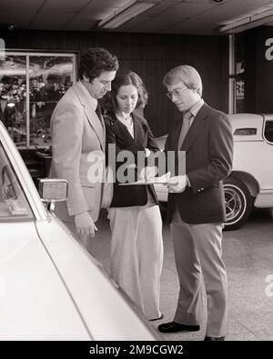 1970S HOMME ET FEMME DANS LA CONCESSION DE VOITURE DISCUTANT AVEC LE VENDEUR EN ALLANT AU-DESSUS DES SPÉCIFICATIONS ET DES PRIX - M9755 HAR001 STYLE HARS COMMUNICATION INFORMATION SUR LE VÉHICULE SHOWROOM STYLE DE VIE FEMMES EMPLOIS MARIÉS MONTRANT CONJOINT MARI ESPACE DE COPIE PLEINE LONGUEUR FEMMES MI-LONGUEUR CONCESSIONNAIRES PERSONNES ACHÈTENT AUTOMOBILE HOMMES CONCESSIONNAIRE TRANSPORT B&W PARTENAIRE SHOPPER SHOPPERS COMPÉTENCE RÊVES PROFESSION VENDRE COMPÉTENCES AVENTURE SERVICE À LA CLIENTÈLE SEDAN AUTOS OPPORTUNITÉ OCCUPATIONS ACHAT AUTOMOBILES VÉHICULES ADULTE MOYEN ADULTE HOMME ADULTE MOYEN-ADULTE FEMME VENTESHOMMES FEMMES NOIR ET BLANC RACE BLANCHE HAR001 OLD FASHIONED Banque D'Images