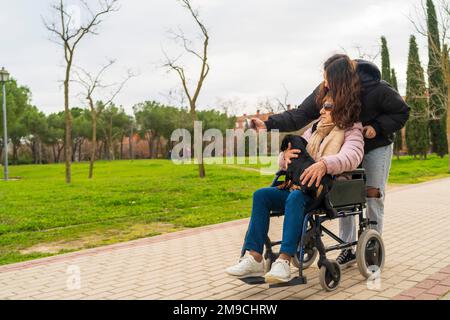 une fille prenant des photos avec sa grand-mère dans un fauteuil roulant Banque D'Images