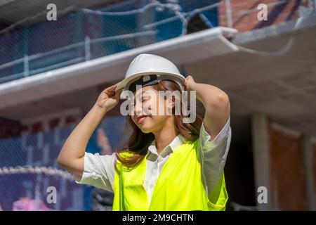femme architecte mettant son casque de sécurité Banque D'Images