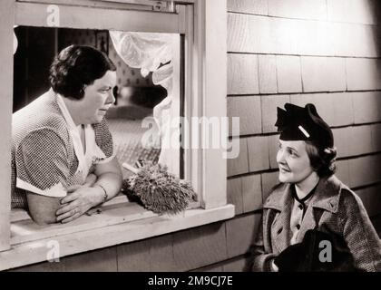 1930S DEUX FEMMES QUI COMMETTENT LA FEMME AU FOYER PENCHÉE PAR LA FENÊTRE AVEC DUSTER PARLANT À LA FEMME VOISINE PORTANT UN MANTEAU DE CHAPEAU - S7904 HAR001 HARS AMITIÉ FEMMES FEMME DE MÉNAGE DEMI-LONGUEUR SŒURS SŒURS DUSTER GOSSIPING B&W FEMME DE FAMILLE D'ÂGE MOYEN FEMMES DE QUARTIER FEMMES DE FAMILLE FRÈRE VOISIN RUMEUR ÉLÉGANTE FENÊTRE OUVERTE TOGETHERNESS SEUIL DE FENÊTRE NOIR ET BLANC CAUCASIEN ETHNICITÉ HAR001 ANCIENNE Banque D'Images