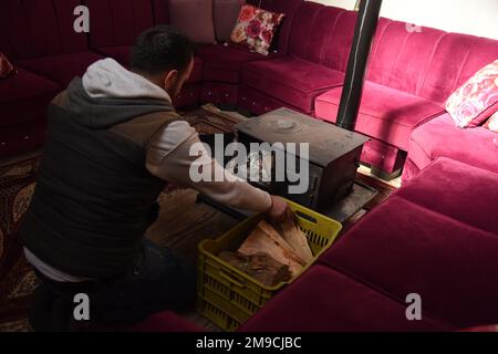 Akkar, Liban. 17th janvier 2023. Un homme allume un poêle à bois pour le chauffage dans sa maison dans le gouvernorat d'Akkar, au nord du Liban, le 17 janvier 2023. Mardi, le chef du Hezbollah a accusé les États-Unis d'empêcher le Liban de prendre gratuitement du carburant en Iran alors que son pays souffre de coupures de courant. Le Liban souffre depuis des décennies de pannes de courant. Son effondrement économique depuis 2019 a accablé le trésor de l'État, ralentissant les importations de carburant pour maintenir le fonctionnement des centrales électriques restantes. Credit: Khaled Habashiti/Xinhua/Alamy Live News Banque D'Images