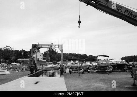 Une grue est suspendue devant une marina avec des rangées de bateaux à quai secs dans l'Essex, Massachusetts. L'image a été capturée sur un film analogique. Banque D'Images