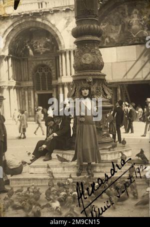 Une femme se tient parmi les pigeons de la place Saint-Marc, à Venise Banque D'Images