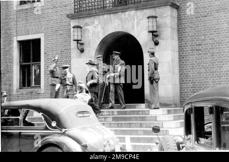 Des officiers de l'armée britannique quittent un bâtiment en Allemagne, à la fin de la Seconde Guerre mondiale. Trois soldats les saluent. Banque D'Images