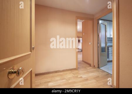 Hall d'entrée d'une maison avec une porte en hêtre et accès à plusieurs chambres avec des portes de même matériau et parquet en chêne Banque D'Images