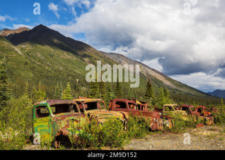 Une gamme de camions rouillés abandonnés après la guerre qui rouillent dans le désert pendant l'été dans le nord du Canada Banque D'Images