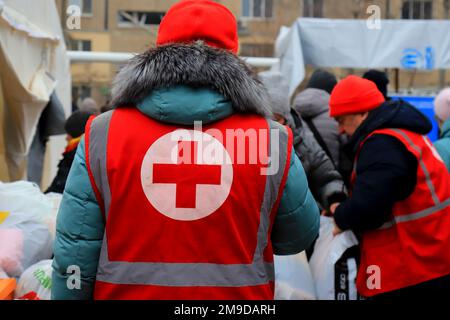 Dnipro Ukraine 2023-01-14. Les volontaires de la Croix-Rouge aident les blessés près d'une maison détruite après une attaque de missiles russes. Signe de croix rouge sur l'uniforme d'ambulancier Banque D'Images