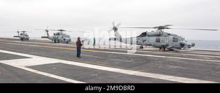 220517-N-LY692-2050 OCÉAN PACIFIQUE (17 mai 2022) trois hélicoptères MH-60R Sea Hawk, provenant des « Battlecats » de l'escadron de frappe maritime d'hélicoptère (HSM) 73, reposent sur le pont de vol du porte-avions USS Nimitz (CVN 68). Nimitz mène une formation sur mesure sur la disponibilité des navires et des problèmes d'évaluation finale (TSTA/FEP). TSTA prépare le navire et l'équipage à une intégration complète dans un groupe de grève des transporteurs par le biais d'un large éventail d'opérations critiques. Banque D'Images