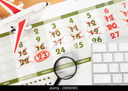 Calendrier et rappels pour les voyages d'affaires, les voyages et les vacances. planeur sur le bureau avec avion et loupe et stylo, clavier. marquage important Banque D'Images