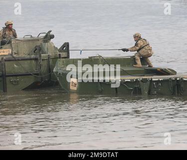 Un soldat du 11th Engineer Battalion, 2nd Infantry Division (ROK-US Combined Division) relie la baie de pont flottant au bateau tout en assemblant des baies de pont pour traverser une rivière, République de Corée, 18 mai 2022; Le bataillon du génie 11th et le 4th Escadron, le 70th Armour Regiment, la 1st Brigade blindée, la 1st Armored Division ont travaillé ensemble à la construction d'un pont de ruban amélioré (IRB) pour permettre le passage par les chars M1A2 Abrams et les M2 véhicules de combat Bradly Infantry. Des soldats de l’équipe de combat de la Brigade blindée de 1st « Ready First », 1st Armored Division (l’actuelle 2nd Infantry Division (ROK-US) Banque D'Images