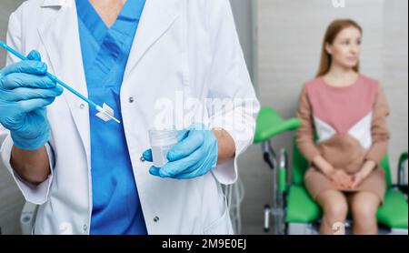 Cytobrush pour l'échantillonnage des cellules endocervicales dans les mains du médecin pendant le test PAP sur la patiente dans le bureau de gynécologue. Test PAP, test de dépistage cervical Banque D'Images
