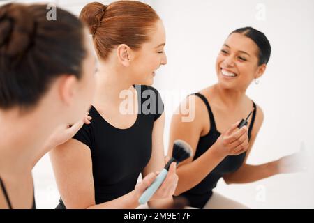 Un rêve à haute voix. un groupe de danseurs de ballet se préparant à aller sur scène et à appliquer le maquillage ensemble. Banque D'Images