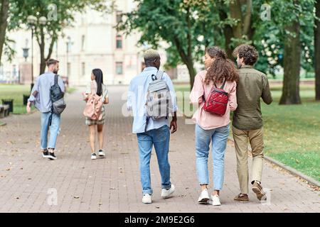 groupe multinational d'amis étudiants marchant dans le parc. Banque D'Images