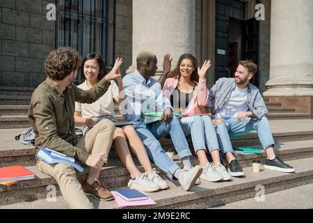 des amis étudiants se donnant un haut cinq. éducation, jeunesse, amitié. Banque D'Images