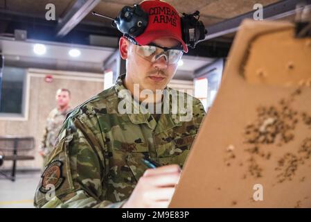 Le principal Airman Jacob Kubek, instructeur d'armes de combat des forces de sécurité 88th, marque une cible après une ronde d'incendie dans la partie M4 de l'événement de tir Excellence in Competition de la semaine de police 17 mai 2022, à la base aérienne de Wright-Patterson, Ohio, alors qu'un concurrent regarde derrière la ligne de tir. Les aviateurs Wright-Patt et les membres des services de police locaux se sont affrontés pour voir qui était le meilleur tir avec M4 fusils et 9mm pistolets. Banque D'Images