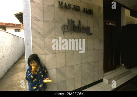 Portrait d'un enfant devant une mosquée située dans un quartier dense près de Gegerkalong, à Bandung, Java-Ouest, Indonésie. Banque D'Images