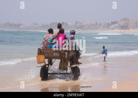 Famille sur une calèche circulant sur les plages du quartier populaire de Yoff à Dakar, Sénégal Banque D'Images