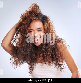 Une bonne tête de cheveux fait toute la différence. Portrait court d'une jeune femme attrayante posant en studio sur un fond gris. Banque D'Images