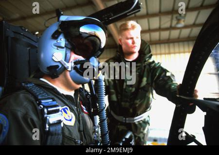Portant le casque à bout de dent qui lui donne un avantage dans un combat de chien, le major de l'US Air Force Mike Brewer prépare un vol d'essai dans un F-15 Eagle. Joshua Christiansen (à droite), chef d'équipage, de l'USAF AIRMAN First Class, a déclaré qu'il aimait le casque « parce qu'il aidera un pilote à ramener mon avion à la maison en une seule pièce ». Cette photo est tirée de l'article du magazine AIRMAN de novembre 1999 « Fly-by Shooting ». Base: Edwards Air Force base État: Californie (CA) pays: États-Unis d'Amérique (USA) Banque D'Images