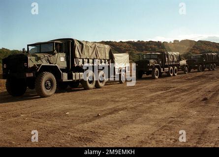 Vue avant gauche d'un convoi US Marine de camions de 5 tonnes M923A1 (6X6) avec deux remorques à roues tractées. Les Marines, de Headquarters Battery, 3rd Bataillon, 12th Marines de la base du corps de Marines, Camp Hansen, Okinawa, Japon, arrivent au camp de base d'Ojojihara pour une fusillade de relocalisation de l'artillerie. Sujet opération/série: OJOJIHARA base DE TIR DE RELOCALISATION D'ARTILLERIE: Ojojihara base Camp pays: Japon (JPN) Banque D'Images