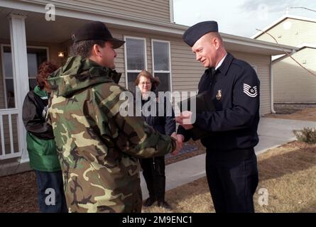 319th Commandant de l'escadre de ravitaillement en air, Colonel V.M. 'Rusty' Findley (à gauche) passe une clé au sergent technique Richard lien, 319th Escadron de génie civil. La clé sera utilisée pour déverrouiller la porte de l'une des deux premières nouvelles unités de logement de la base aérienne de Grand Forks, Dakota du Nord, offertes au personnel de la base sur 13 décembre 1999. Les deux sont la première des 60 nouvelles unités qui seront remplies d'ici juin 2000. Base: Base aérienne de Grand Forks État: Dakota du Nord (ND) pays: États-Unis d'Amérique (USA) Banque D'Images