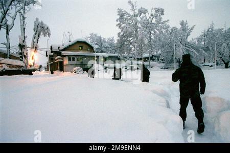 Tout droit, sur la vue arrière, un tir moyen tandis que des militaires multinationaux traversent 3 mètres de neige en étant stationnés à Ilidza, enceinte de Sarajevo, en Bosnie, pour soutenir l'opération joint Forge. Sarajevo a rencontré la plus grande quantité de neige en 50 ans cet hiver. Les routes ont été fermées et certaines entreprises (routes et entreprises non représentées) ont été fermées pendant les quatre jours de fortes chutes de neige. Objet opération/série: BASE DE FORGE COMMUNE: Llidza pays: Bosnie-Herzégovine (BIH) Banque D'Images