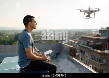 Jeune technicien homme volant UAV drone avec télécommande dans la ville Banque D'Images