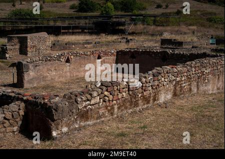 Niches Columbaria en brique à pignons, de type colomvecote, pour la crémation de bas statut, les interments bordent les murs intérieurs d'une nécropole dans l'ancienne Velia à Marina di Ascea, Campanie, dans le sud de l'Italie. Au-delà, les toits plats modernes protègent les vestiges excavés d'une insula, un immeuble probablement construit à l'époque hellénistique, puis restauré par les Romains. Banque D'Images