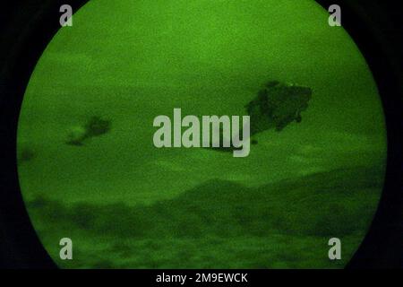 Vue de face du côté droit depuis un angle bas vers le haut lors d'un tir de nuit à travers un système Starlight alors que les hélicoptères Seahawk HH-60 de la marine américaine affectés à l'escadron anti-sous-marin de l'escadre Pacifique de l'hélicoptère, viennent pour un atterrissage d'assaut pour ramasser des hommes de camp (non illustré). Desert Rescue est la première recherche et sauvetage (SAR), formation menée dans les gammes de Fallon Naval Air Station, Nevada. Cette mission est un soutien indirect de l'exercice Desert Rescue VIII Sujet opération/série: BASE DE SAUVETAGE DANS LE DÉSERT: Station navale aérienne, Fallon État: Nevada (NV) pays: États-Unis d'Amérique (USA) Banque D'Images