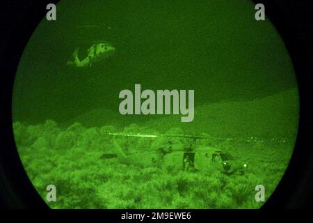Vue de face droite tir moyen la nuit à travers un système Starlight alors que des hélicoptères Seahawk HH-60 de la marine américaine affectés à l'Escadron anti-sous-marin de l'escadre du Pacifique prennent un équipage. Desert Rescue est la première recherche et sauvetage (SAR), formation menée dans les gammes de Fallon Naval Air Station, Nevada. Cette mission est un soutien indirect de l'exercice Desert Rescue VIII Sujet opération/série: BASE DE SAUVETAGE DANS LE DÉSERT: Station navale aérienne, Fallon État: Nevada (NV) pays: États-Unis d'Amérique (USA) Banque D'Images