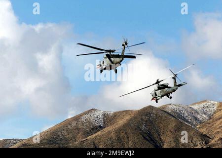 Vue arrière du côté gauche vue moyenne vue longue vue depuis un angle bas, regardant deux HH-60 de la marine américaine depuis des hélicoptères de l'escadre anti-sous-marine du Pacifique stationnés NAS North Island, Coronado Californie, quitte la zone d'atterrissage après avoir ramatré des survivants d'otages simulés de l'ambassade (non illustré). Le sauvetage dans le désert est un exercice de recherche et de sauvetage au combat (RMORCD) conçu pour intégrer pleinement la planification et l'exécution de missions immédiates et dédiées. Objet opération/série: SAUVETAGE DANS LE DÉSERT VIII base: Station aérienne navale, Fallon État: Nevada (NV) pays: États-Unis d'Amérique (USA) Banque D'Images