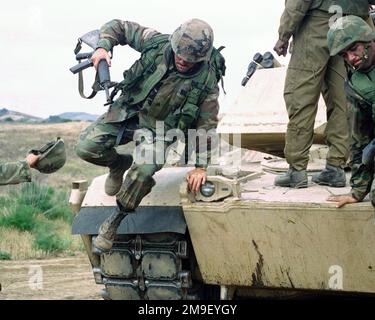 LE caporal DU corps maritime DES ÉTATS-UNIS (CPL) Eric J. Staley, 2nd Bataillon 7th Marine Regiment, tenant un fusil d'assaut M16A2 de 5,56mm qui saute d'un char de combat principal (MBT) M1A1 Abrams lors d'un exercice d'instruction d'opération amphibie (AOT) au Camp Pendleton, en Californie. Base: Corps de marine base Camp Pendleton État: Californie (CA) pays: Etats-Unis d'Amérique (USA) Banque D'Images