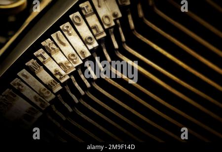Mise au point peu profonde sur les caractères de type d'une machine à écrire antique. Mise au point dure au centre de l'image et mise au point douce sur les bords Banque D'Images