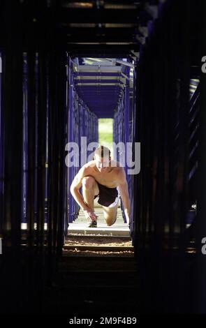 Sous les gradins, le capitaine Jeff Kuzma de la Force aérienne des États-Unis, ingénieur spatial, s'étire après une séance d'entraînement. Il s'entraîne pour faire l'équipe olympique américaine dans la course de 800 mètres. CPT Kuzma fait partie du programme des athlètes de classe mondiale qui offre aux athlètes actifs de service, de garde et de réserve la possibilité de s'entraîner à temps plein dans leur sport pendant deux ans. Pluie ou brillance, CAPT. Kuzma court à des kilomètres autour du terrain de l'Académie de l'Armée de l'Air. Son but est une médaille olympique et le renforcement de la reconnaissance et de la sensibilisation de la Force aérienne dans la communauté publique, 21 juin 2000. Base : US Air Force Academy St Banque D'Images