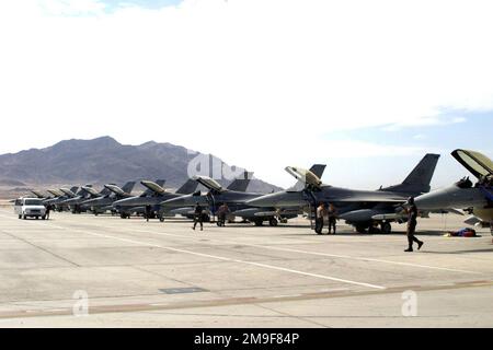 Tir moyen long, vue de face gauche, rangée de dix F-16C Faucon Fighting garés sur la ligne de vol, nuages blancs, ciel bleu et montagnes en arrière-plan, personnel autour de plusieurs de l'avion. Les faucons de combat du 23rd Fighter Squadron, base aérienne de Spangdahlem, en Allemagne, se préparent au premier vol du dernier exercice du drapeau vert, base aérienne de Nellis, au Nevada. Objet opération/série : BASE DRAPEAU VERT : base aérienne de Nellis État : Nevada (NV) pays : États-Unis d'Amérique (USA) Banque D'Images