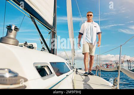 Voyage sur l'océan et homme sur un bateau de luxe pour l'aventure des retraités, les vacances et la voile en plein soleil d'été. Détendez-vous, vacances et homme mûr marchant sur le yacht Banque D'Images