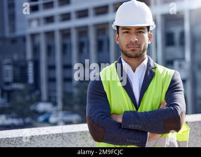 La concentration et la détermination permettront de faire le travail. un jeune homme d'affaires travaillant sur un chantier de construction. Banque D'Images