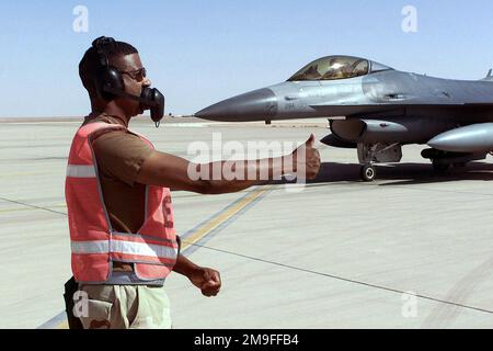 Un CHEF d'équipe de chargement d'armes Faucon F-16 de la Force aérienne des États-Unis, de la base aérienne de Spandahlem, en Allemagne, remet un pouce au pilote après l'armement de l'avion à la base aérienne du Prince Sultan, en Arabie Saoudite, pendant l'opération SOUTHERN WATCH. Le F-16 fait partie des forces de la coalition de l'aile expéditionnaire aérienne de 363d, Prince Sultan AB, SAU, qui applique la zone d'exclusion aérienne et de non-conduite dans le sud de l'Irak pour protéger et défendre contre l'agression iraquienne. Objet opération/série : BASE DE SURVEILLANCE SUD : base aérienne de Prince Sultan pays : Arabie saoudite (SAU) Banque D'Images