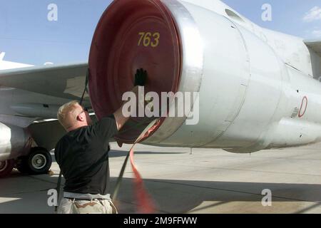 AUSTIN B. Mayer, ancien AVIATEUR DE la Force aérienne DES ÉTATS-UNIS, technicien en hydraulique, Escadron de reconnaissance expéditionnaire du 363rd, base aérienne du Prince Sultan, Arabie saoudite, place une couverture sur un moteur d'avion de reconnaissance conjoint du Rivet RC-135 de l'USAF dans le cadre de ses procédures post-vol à la base, sur 26 octobre 2000. SRA Mayer fait partie de la force de coalition qui soutient ici l'opération SOUTHERN WATCH, un effort militaire visant à faire respecter la zone d'exclusion aérienne et de non-conduite dans le sud de l'Irak. Objet opération/série : BASE DE SURVEILLANCE SUD : base aérienne de Prince Sultan pays : Arabie saoudite (SAU) Banque D'Images