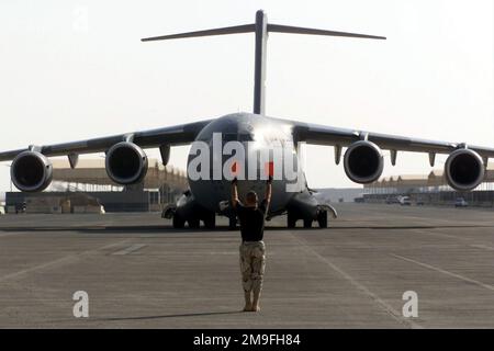 Un membre du 8th Expeditionary Air Mobility support Squadron, base aérienne de Prince Sultan (Arabie saoudite), marshalls dans un C-17 Globemaster III de l'aile 437th Air Mobility pendant l'opération SOUTHERN WATCH. Le maréchal fait partie des forces de coalition de l'aile expéditionnaire aérienne de 363rd qui applique la zone d'exclusion aérienne et de non-déplacement dans le sud de l'Irak pour protéger et défendre contre l'agression irakienne. Objet opération/série : BASE DE SURVEILLANCE SUD : base aérienne de Prince Sultan pays : Arabie saoudite (SAU) Banque D'Images